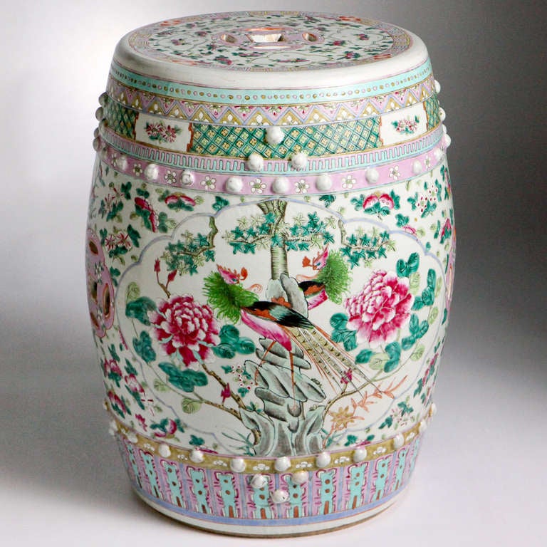 Beautiful Classic ceramic garden seat in an Oriental pattern. The sides with keyhole cutouts, painted scenes with colorful peacocks and large chrysanthemum flowers in rich pink, lavender, turquoise and green colors on a cream background.