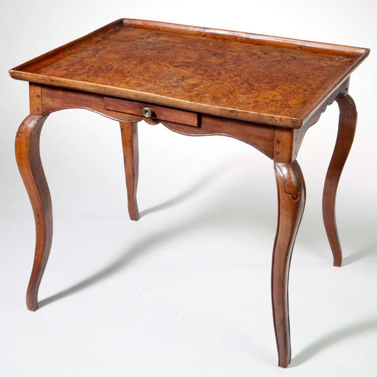 Early 19th century French burled elmwood table. Suitable for large side table with beautiful burled wood top designed in a tray style with a raised edge that rests on gracefully arched and tapered legs.