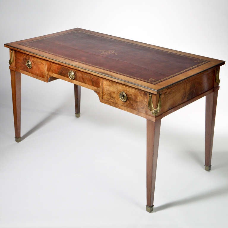 19th C. French walnut writing table or bureau plat.  Beautiful polished burled walnut desk with brass swag overlays on each corner, the top inlaid with tooled leather, the legs tapered with brass fittings at the ends.  One large center drawer with
