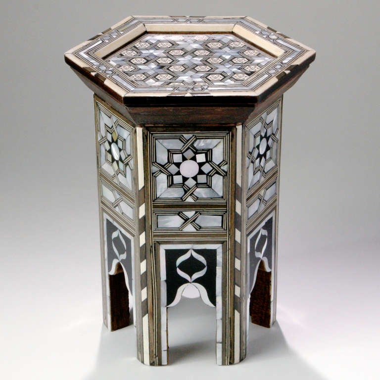 Miniature Syrian hexagonal walnut stand ornamented in geometrical mosaics of mother-of-pearl inlay and camel bone detailing. Perfect display pedestal or base for large pillar candles. Limited edition of six pieces; price for each.