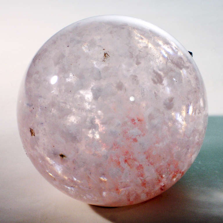 Extra-large rock crystal ball with variegated pink color throughout.