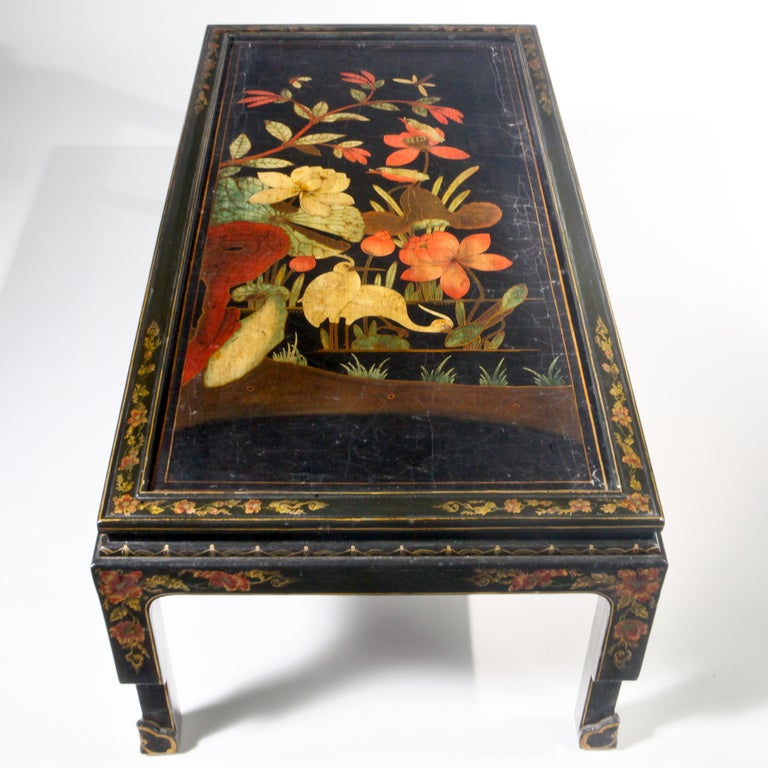 Long rectangular 18th century oriental black lacquered coffee table with large-scale bird and flower patterns. Designed using an antique painted oriental chinoiserie panel or screen that has been fitted to a custom designed base with extensive