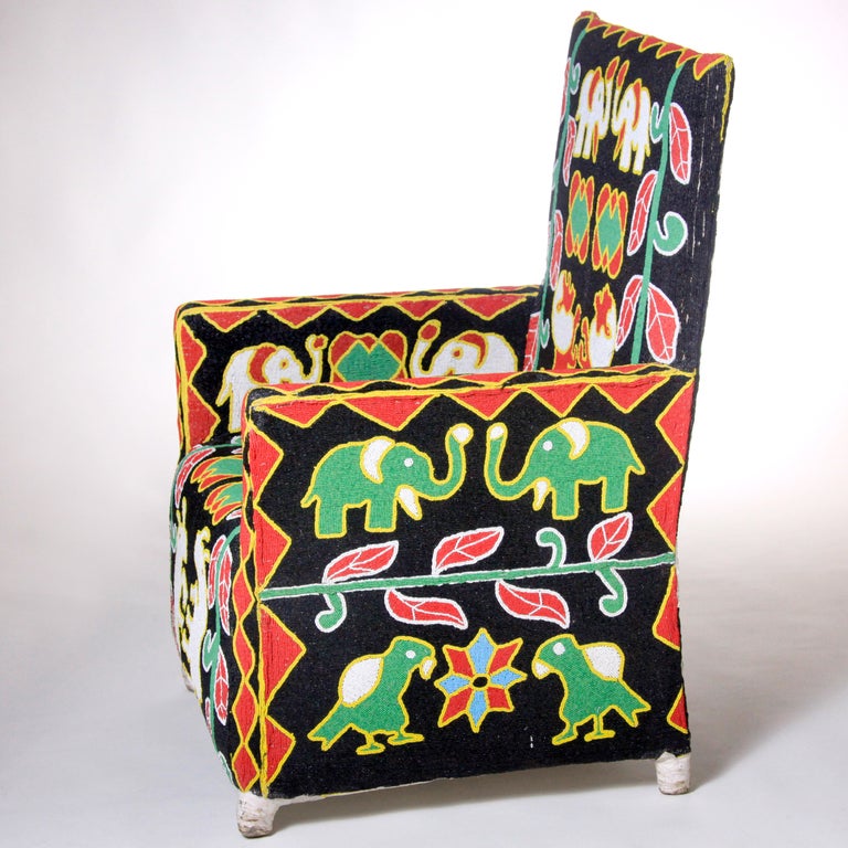 Exquisitely crafted Nigerian chair in vivid primary colors on black background.  Canvas covered wood frame chair  with extensive hand beading.  African artists used native animals (elephants, lions, rhinos and birds) juxtaposed with plant shapes and