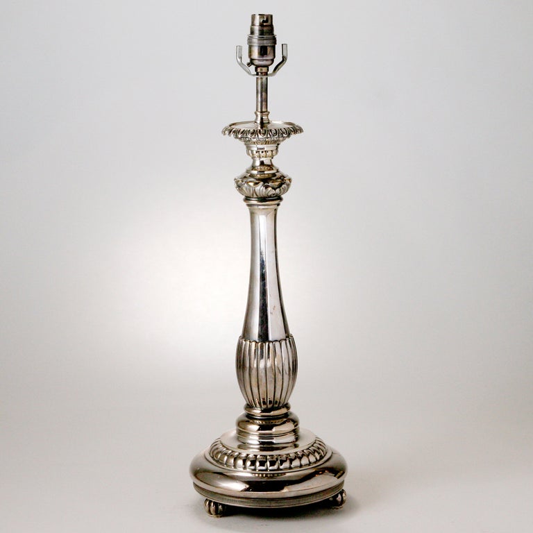 Silver plate candlestick table lamp with fluted column and decorative round base.