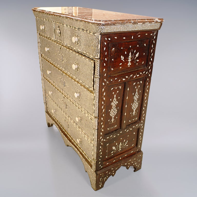 Exceptional finely detailed antique Syrian mother-of-pearl five-drawer chest of drawers. Traditional design with each drawer and knob outlined in raised herringbone pattern. Rich rouge variegated marble top with bevelled edge.