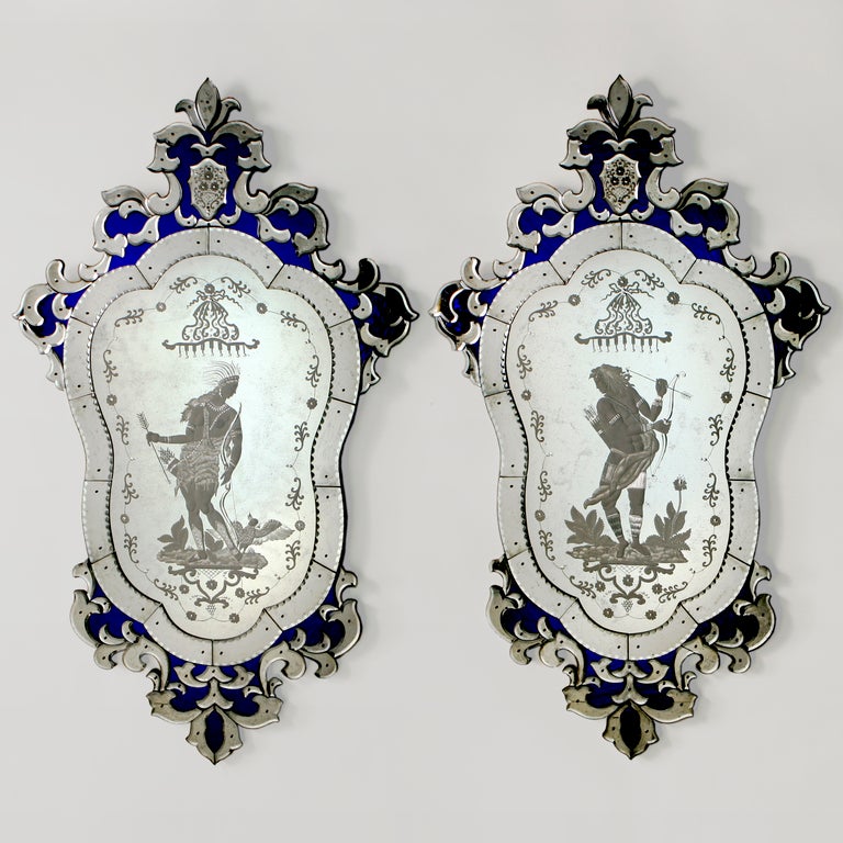 A pair of handcrafted Venetian glass mirrors etched with male and female figures and cobalt blue glass inlay detailing. Limited edition.