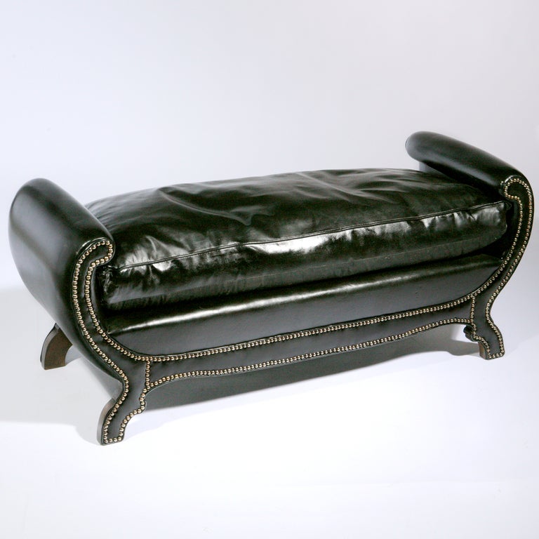Traditional English Regency long black leather bench with rolled arms and shiny silver tone nailheads.