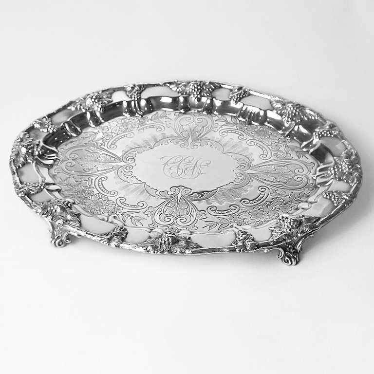 Oval flower pattern silver salver tray with embossed grape pattern border. Raised on scroll shaped feet. Sheffield silver, circa 1845.