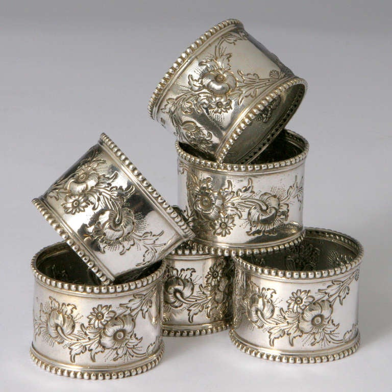 Set of eight hallmarked sterling silver napkin rings. Each ring features a traditional delicately engraved flower pattern.