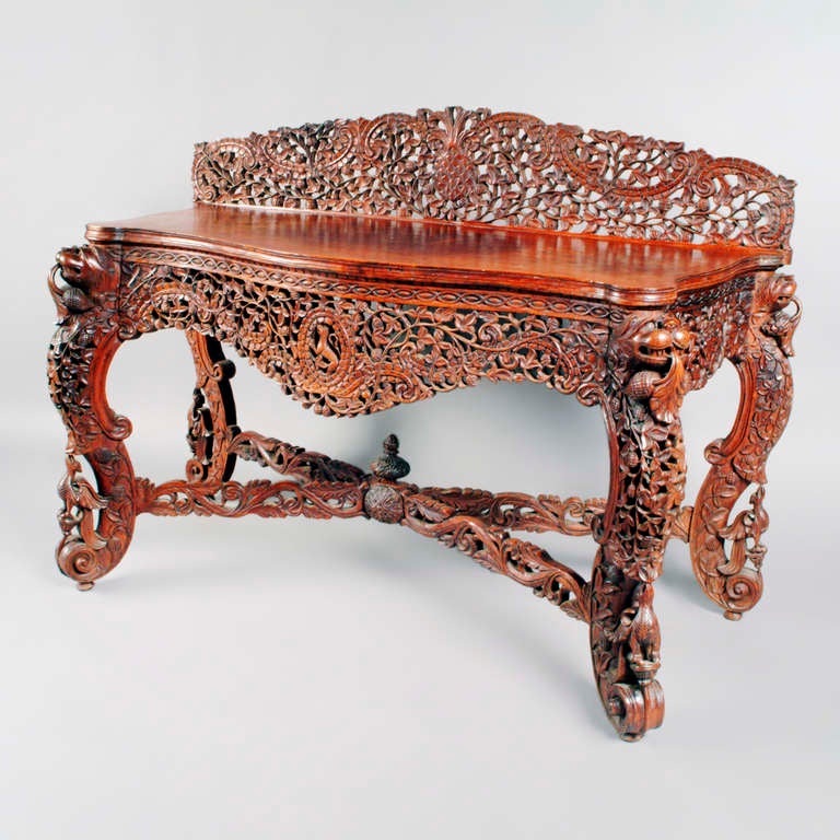 Important Anglo-Indian rosewood console table with ornately carved apron front, high back, legs and stretchers.