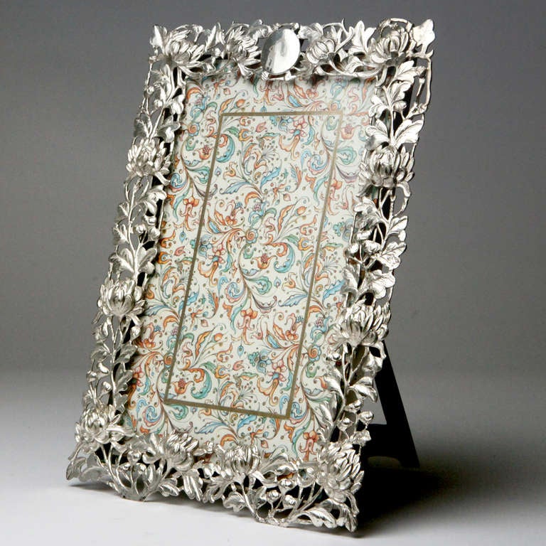 Beautifully detailed silver picture frame with a wide border of chrysanthemum flowers in high relief and a center engraveable medallion.  Late 19th century Chinese export silver made by Hung Chong & Co from Shanghai and Canton, China.  They were