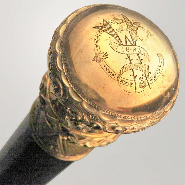 From a private old New York collection, a fine Victorian presentation cane with rolled gold knob and ebonized hardwood shaft. Geometric and scroll pattern in relief. Top of knob monogrammed 
