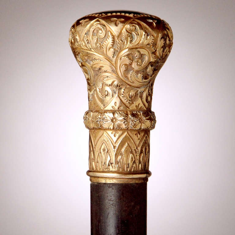 From a private old New York collection, a fine Victorian presentation cane with rolled gold knob and ebonized hardwood shaft. Elaborate scrollwork and arch design in relief.  Top of knob perfect for monogramming!