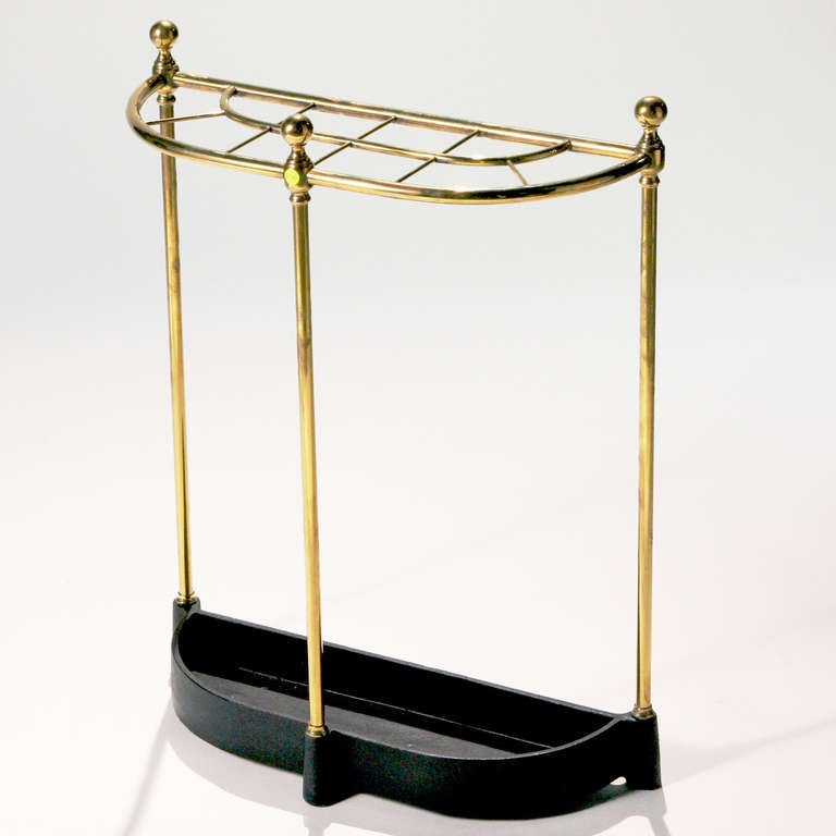 Hard-to-find antique 19th century crescent-shaped brass stick stand with black metal drip tray.