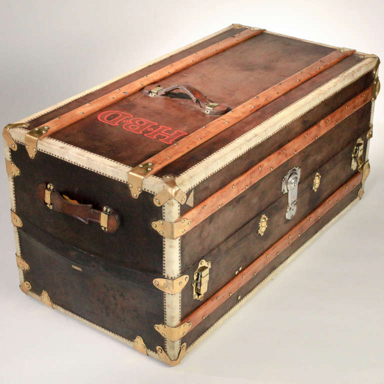 Large vintage French leather steamer trunk with wood struts and brass appointments. The interior with original wallpaper and matching fabric. Five side drawers and hanging wardrobe section. The brass corners stamped "L G depose Paris;"