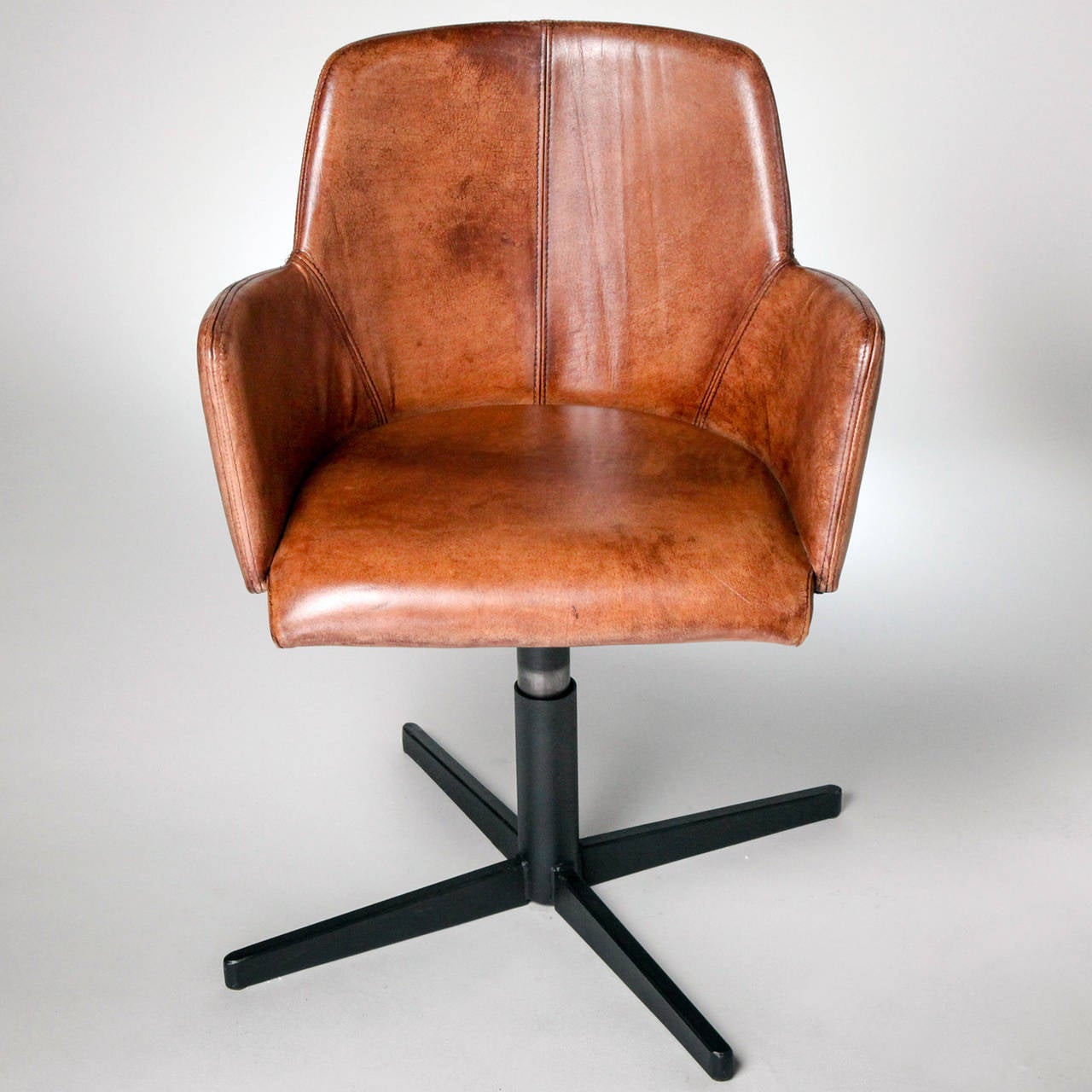 Limited edition swivel style chair in mottled brown leather. Black metal base.