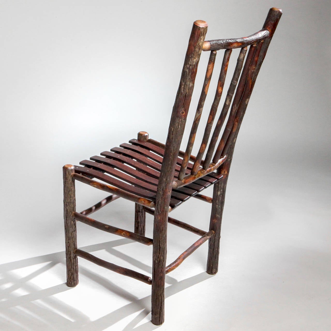 Handcrafted Adirondack hall or dining natural wood chair with spindle chair back and split wood seat.