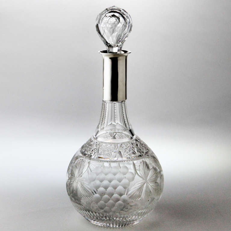 Crystal decanter with sterling-clad neck and faceted stopper, engraved with large grapes and grape leaves. Hallmarked: Birmingham, 1928.