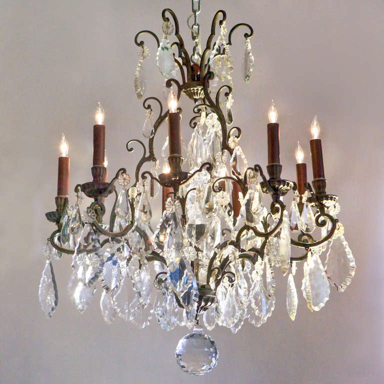 Magnificent nine-light crystal chandelier with wonderful old French bronze frame. Scrolled arms hung with exceptional large flat-cut crystal pendants. Tall crystal spire embellishes the center space and hanging faceted crystal ball drops down to
