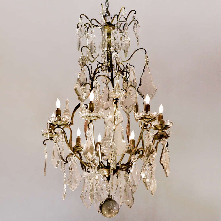 Stylish nine-light chandelier with hand cut Bohemian crystals. Bronze frame chandelier with many faceted crystal shapes including plaquettes, rosettes, spheres and crystal bobeches.