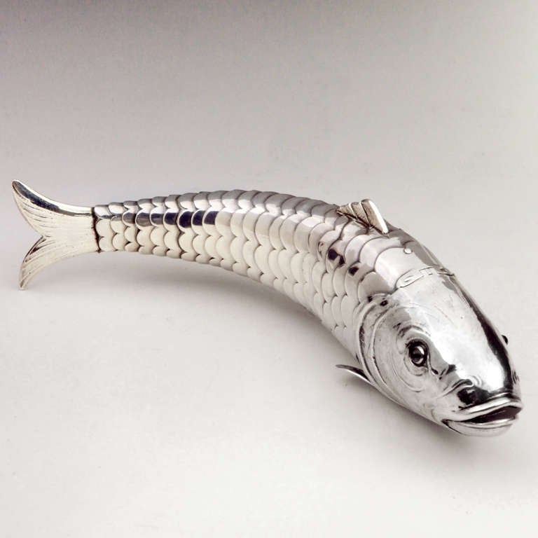 Hallmarked antique silver box in the form of an articulated fish with gemstone set red eyes. Hinged head and mouth open to hold trinkets or spices.