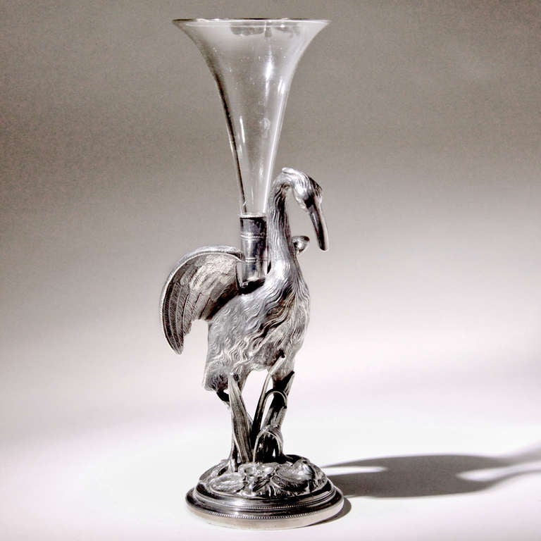 Distinctive Victorian silver plate and glass heron vase. The tall heron figure standing among leaves and bulrushes on a domed base. The heron supporting a glass bud vase insert. Designed by Thomas Wilkinson & Sons, Birmingham, England – the company