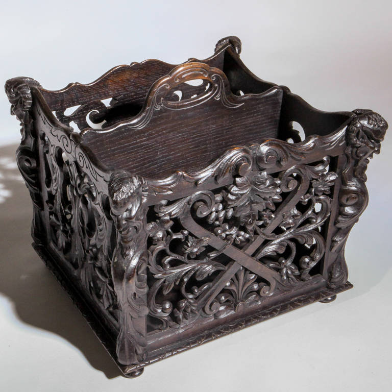 Intricately carved Black Forest Canterbury or magazine rack. Designed in a swirled leaf pattern with horned grotesque figures on each corner.