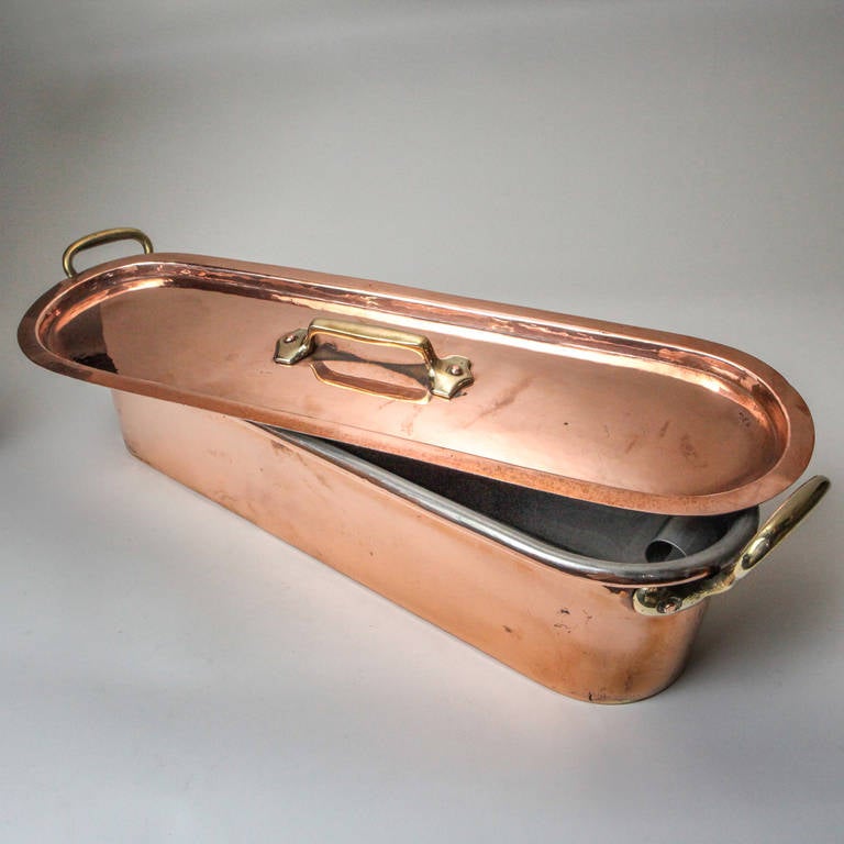 Exceptional French copper fish poacher. Large traditional oval size in copper with brass handles and rare-to-find original metal steamer insert.