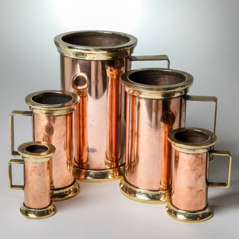 Set of five antique decorative tankards.  Heavy weight copper tankards handsomely accented with brass handles, lips, and bases. Graduating in size from tiny 3.25