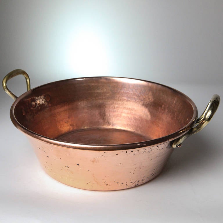 Antique French copper pot with brass handles. Hammered with traditional pebble finish.