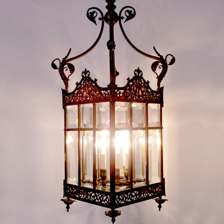 Elegantly detailed four-light pierced brass lantern or hall light with rare original beveled glass panels. Top crown piece (not shown) mirrors the motif of the four feet.