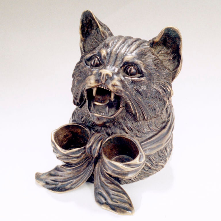 For cat lovers, bronze humidor realistically shaped as a cat's head. Opens to reveal humidor space. Large ribbon around neck forms two storage bowls.