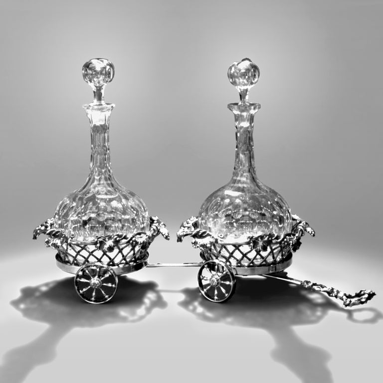Victorian two-bottle cut crystal decanter set with chased silver grapevine and basket weave pattern trolley on wheels. Hallmarked: Mappin and Webb, England, 1880.