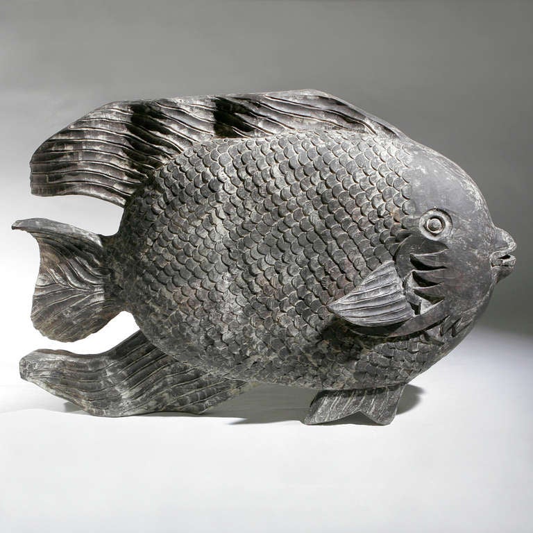 Decorative angel fish with undulating fins and delicately textured scales. Created in carved wood with a weathered patina. One of a series of carved wood fish in approximately two-foot, three-foot, and four foot sizes. This one in large 52"