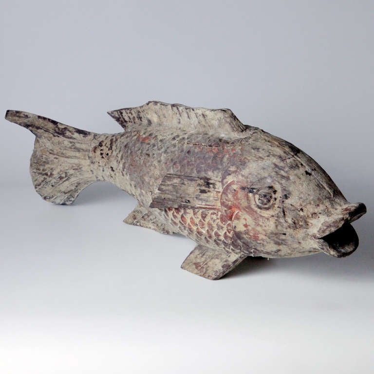 Decorative swimming mudfish with undulating fins and delicately textured scales. Created in carved wood with a light weathered patina.