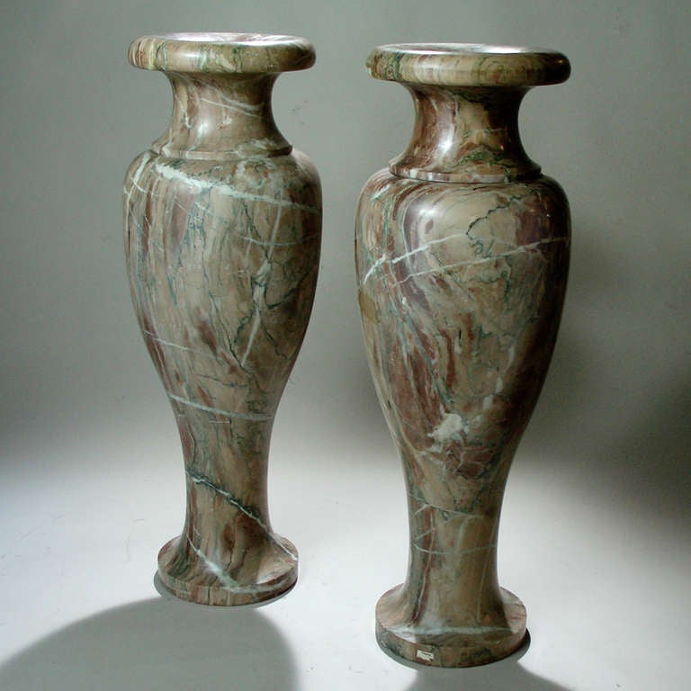 Pair of rose marble urn-shaped floor vases.