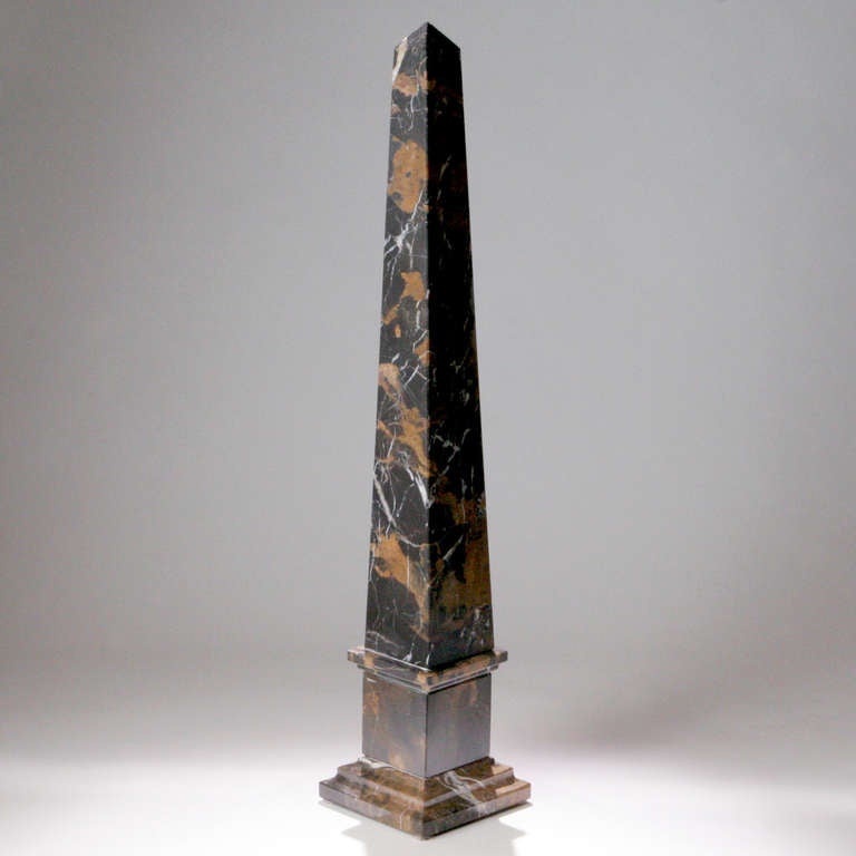 Large size black and gold-veined marble obelisk.