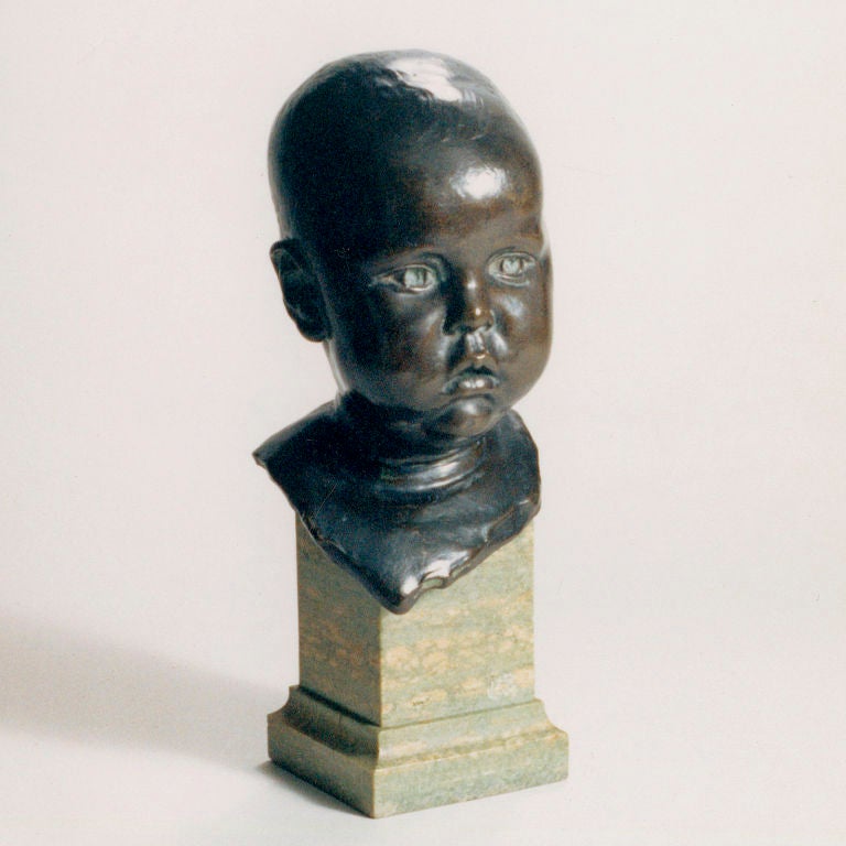 Traditional Victorian baby bust. Bronze bust set on variegated marble base. Inscribed: R. Blackburne.