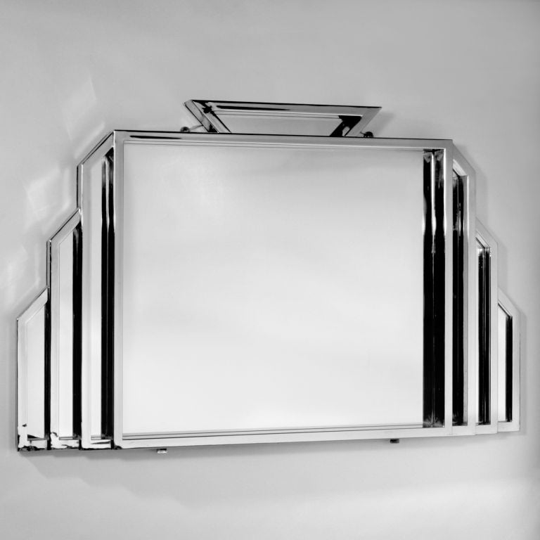 Set of four extra-large Art Deco mirrors right out of an Irish cafe. Each over four feet wide and almost three feet high in a polished metal with structured panels outlining the center mirror. For stability they are hung with a supporting shelf