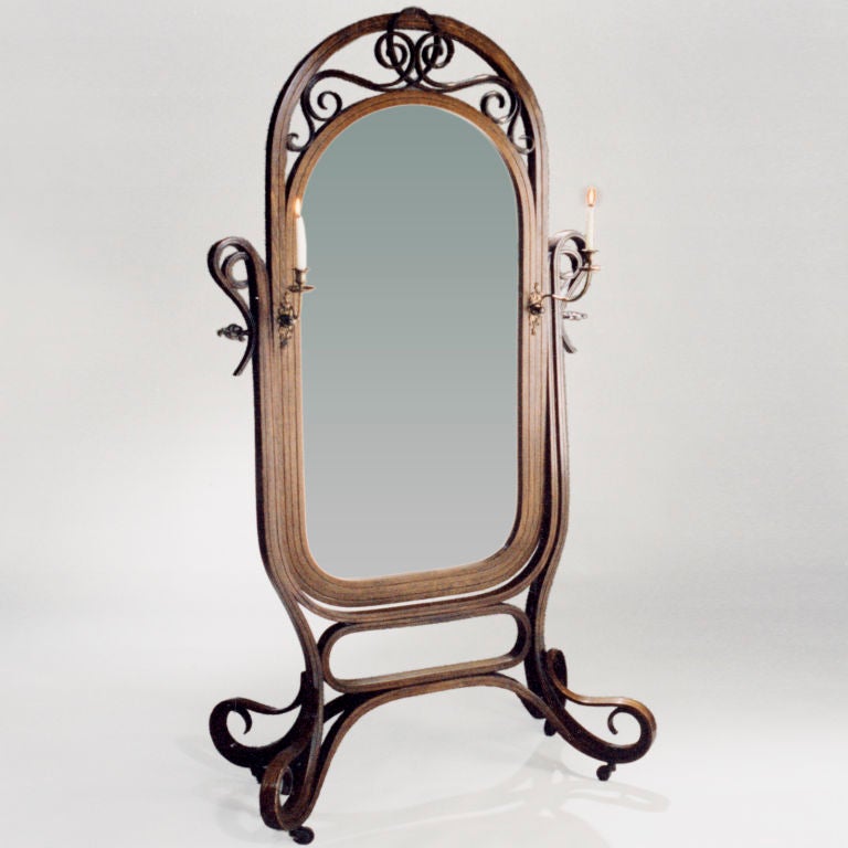 Large bentwood cheval standing mirror with attached metal candleholders. Gracefully scrolled legs and top piece balance beveled oval looking glass.