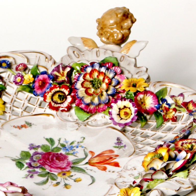 Beautiful antique Staffordshire centrepiece in rich flower garden colors. The dish designed as a lobed shaped open-work basket that features embossed flower garlands and a painted flower centre. The dish supported by four winged cherub figures each