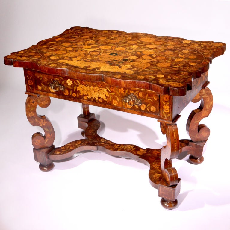 Exquisite 18th century scalloped edged Dutch marquetry center table.  Walnut serpentine top inlaid with richly colored rosewood and satinwood in traditional floral motif, featuring a classic urn overflowing with a profuse arrangement of cascading