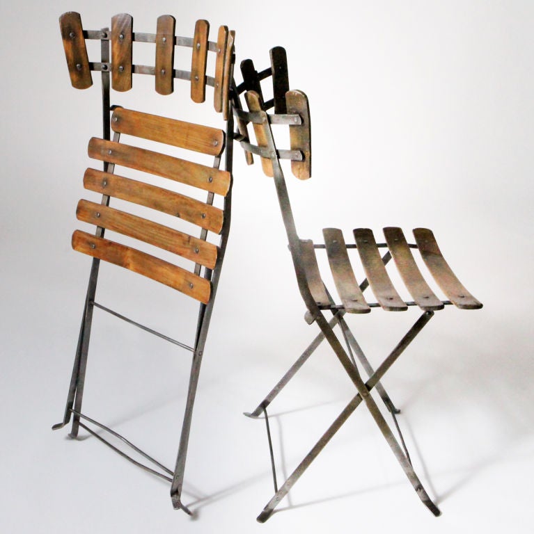 Pair of antique French folding chairs with iron frames. Distinctive vertical beechwood slats form the backs and contrast nicely with the traditional horizontal slated seats.