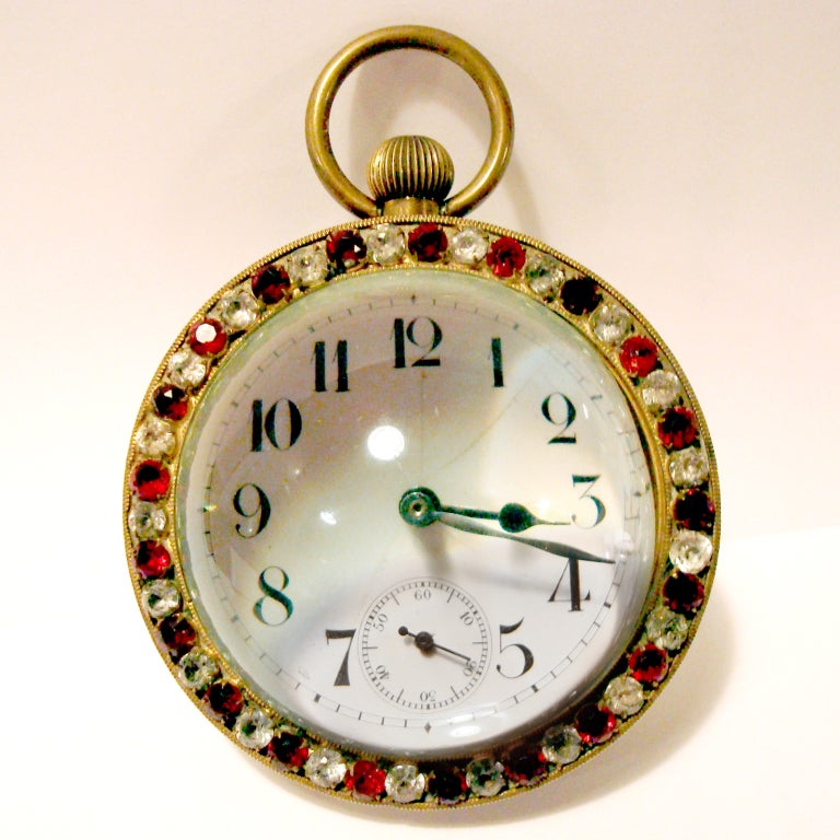 Striking turn of the century large size French diamante glass ball clock with deep red and clear paste stones set into a bronze case.  Magnified glass half-ball back allows you to see intricate French movement.