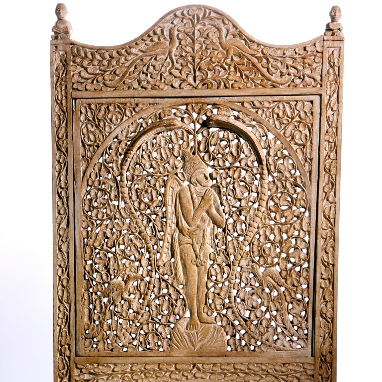 Pair of antique Burmese teak side chairs in a bleached and pickled finish.  Each high back chair hand carved in intricate patterns with ornately carved backs, legs and apron fronts.  Complimentary designs on the back panels: one with a seated figure