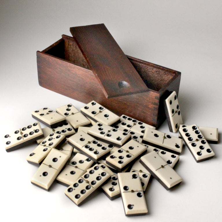 Complete set of twenty-eight dominoes in a wooden box.  Traditional antique style with two tone ebony and ivory pieces.  Spinners: on antique dominoes, each had a raised brass tack so that they could be spun on the table as they were shuffled before