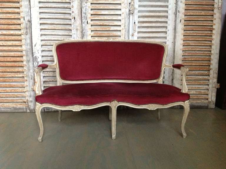 Handsome French settee, upholstered in a rich, red velvet.