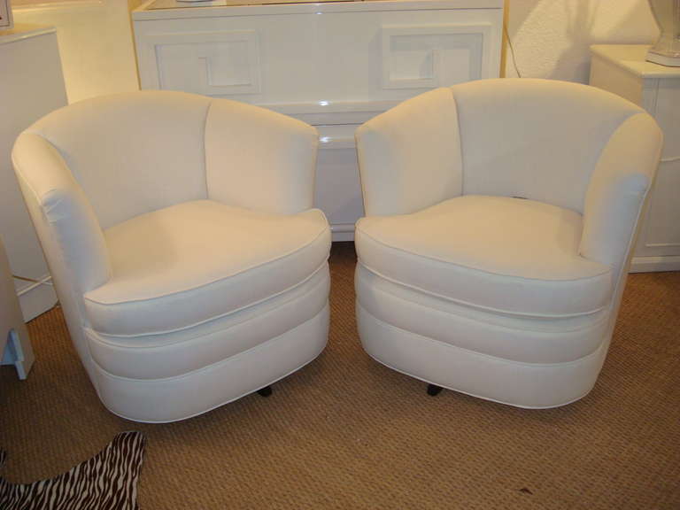 Pair of sassy swivels. Newly reupholstered, rounded tub chairs in white twill cotton.