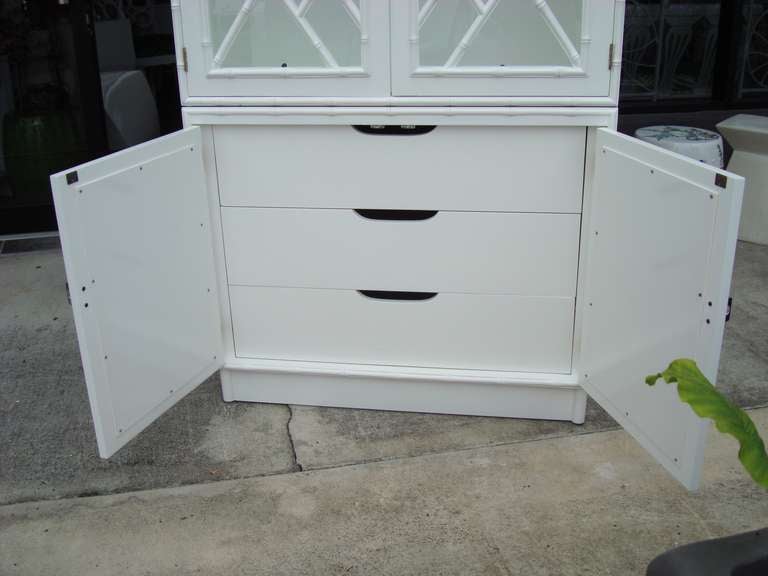 Newly Lacquered White Gloss 2 pc Cabinet
Glass Panel Top Cabinet with Fretwork. and Polished Nickel Pulls
3 Glass Movable Shelves
Lowered Mirrored Panel Cabinet
Three Interior Drawers.

Key: Hollywood Regency, Chippendale, Palm Beach Chic