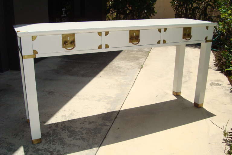 Newly Lacquered White Gloss Mid Century Console with Distinctive Burnished Brass Hardware. Three Drawers.